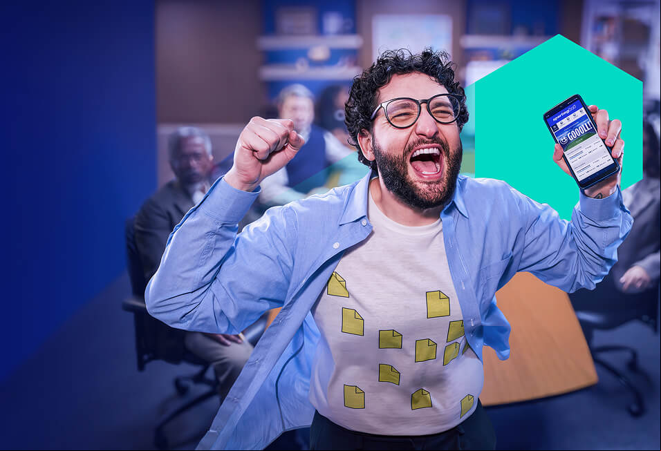 a man cheering holding his phone up